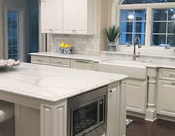 Check out these arctic white quartz countertops compliment by a muted, teal wall and a burst of white cabinets. Best Marble Look Quartz Countertops Quartz Kitchen Countertop Ideas
