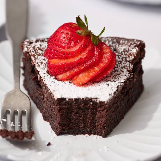 Date Night Chocolate Fudge Cakes served with berries and a dusting of icing sugar