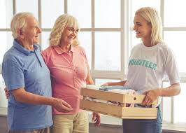 Volunteer And Old People Beautiful Young Female Volunteer Is Giving A Box Of Ne Sponsored Paid Sponsored Beautiful Volunteer Box Young 2020