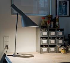 Created for the sas royal hotel in copenhagen in 1957, the combination of right and oblique angles on this piece were intended to parallel the design of scandinavian airlines seats as well as the geometric profile of the company's buildings. Table Lamp Aj Dark Grey L21 5cm H56cm Louis Poulsen Nedgis Lighting