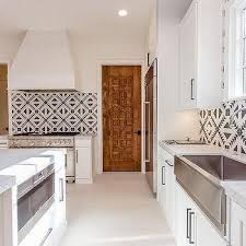 Black And White Mediterranean Kitchen With Carved Wood Door Mediterranean Kitchen Wood Kitchen Cabinets Clean Kitchen Cabinets