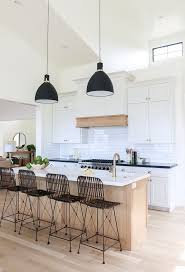 White Kitchen With Light Oak Island And Light Wood Floors The Black Light Fixtures And Counter Sto Interior Design Kitchen Home Decor Kitchen Kitchen Interior