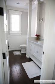 The wooden floor along with the wood panel strike through the contemporary and modern setting of this incredibly sleek and bold bathroom and bring earthy and the light oak wood floor totally works as a buzz in the sleek and white bathroom and provides the interior with vibrant and radiant ambiance. Home Garden White Wood Floor Bathroom Cabinet Bath
