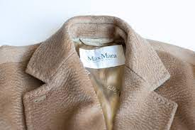 Tailored from sumptuously soft camel hair, this timeless coat features wide shawl lapels that drape into a generous, cozy hood. Wardrobe Staple The Camel Coat Feather Factor