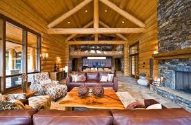 A Living Room With A Stunning Fireplace Sits At The Far End Of The Great Room Surrounded Cabin Interior Design Cabin Living Room Log Cabin Interior