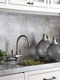 This modern kitchen offers an industrial vibe with a metallic kitchen backsplash which can be both stylish and functional. Metal Backsplash Ideas Metallic Backsplash Backsplash Remodel Kitchen Splashback