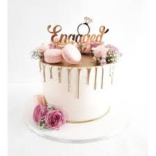 These 14 cake ideas for your engagement party will engage your guests with a sweet sugar high and get the families all set for a combined union! Gold Drip Cake With Fresh Flowers And Macarons Engagement Party Cake Engagement Cake Design Fresh Flower Cake
