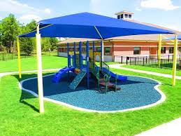 Scene switches to a slight elevated view of a skyways shade sail covering the playground swing set. How To Measure For A Playground Shade Structure Playground Outfitters