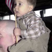 Jay Jernigan (18 months) shows his patriotism by holding the United States  Flag at the USO Tour Concert hosted by the Secretary of Defense, The  Honorable William Cohen, at Ramstein Air Base,