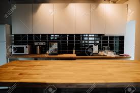 Check spelling or type a new query. Modern Kitchen Features White Flat Front Cabinets Light Wooden Countertop And Glossy Black Linear Backsplash Copy Space Microwave Fridge Coffee Maker Electric Stove And Glasses Stock Photo Picture And Royalty Free Image