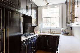 Small Black Contemporary U Shaped Kitchen Features Glossy Black Cabinets Accented With Brass Hardware And A White Black Kitchens Kitchen Remodel Kitchen Design