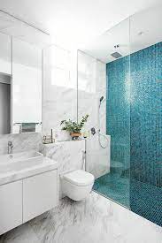 Aménagement d'une petit salle de bain moderne avec un placard à porte plane, des portes de placard en bois sombre, un wc à poser, un carrelage blanc. Modele De Bai In Combinatie Cu Albastru Cele Mai Noi Idei Decorat Ro