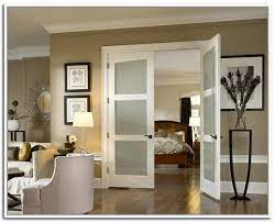 Frosted glass double doors open to an en suite master bathroom boasting a marble tiled floor and a brass cigar table placed beside a catty corner freestanding bathtub. 64 Best French Doors Ideas French Doors Doors Interior Interior Barn Doors