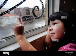Little girl at a rainy window hi-res stock photography and images