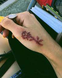 Not All Tattoos Have To Start Off With Black Ink The Use Of Red Ink For This Flower Hand Tattoo Gi Small Hand Tattoos Small Tattoos For Guys Hand Tattoo Ideas