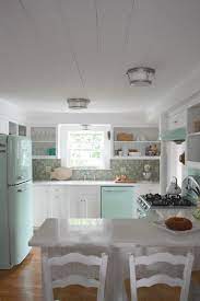 Mugs and vases match beautifully with mint green pendant lights in this small tybee island georgia kitchen. Connecticut Beach House Tour And Retro Kitchen Beach House Kitchens Beach House Interior Beach House Interior Design