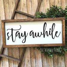 Such a cute sign above the bed and the fan is a perfect idea too! Stay Awhile Entry Decor Guest Bedroom Sign Farmhouse Farmhouse Guest Bedroom Entry Decor Foyer Decorating