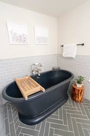 Beebout design master bathroom renovation with herringbone tile floors, brass fixtures, subway tile, and floating vanity. Grey Subway Tile Herringbone Tile Bathroom Fireclay Tile