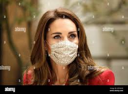 The Duchess of Cambridge listens to pharmacist Joyce Duah (not in picture)  during a visit to St. Bartholomew's Hospital in London, to mark the launch  of the Hold Still photography project Stock
