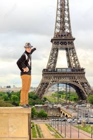 Young Man Hipster In A Hat And Vest Shows The Eiffel Tower La Tour Eiffel  In Paris, France Stock Photo, Picture and Royalty Free Image. Image  29086082.