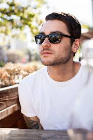 An Attractive Caucasian Man In A White T-shirt Looking Away From The Camera  With Sunglasses On." by Stocksy Contributor "J Danielle Wehunt"