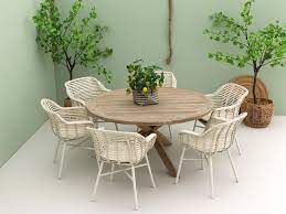 mooie ronde tuintafel van hout met een kruispoot aan de houten tuintafel passen zes tuinstoelen deze witte kuipstoelen tuintafels tuinmeubilair buitentafels