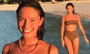 Iris Law looks bronzed and beaming as she celebrates the New Year splashing  in the surf