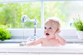 Living room also cat sun bathing. Baby Taking Bath In Kitchen Sink Child Playing With Foam And Soap Bubbles In Sunny Bathroom