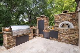 outdoor kitchen with smoker and pizza