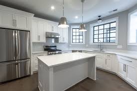 Modern Kitchen With White Cabinets Stainless Steel Appliances Dark Hardwood Floors Pendant Ligh White Modern Kitchen Kitchen Remodel Design Kitchen Flooring