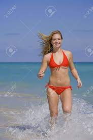 Beautiful Caucasian Female Teenage Running Through To Surf Wearing A  Colorful Bikini. Stock Photo, Picture and Royalty Free Image. Image 2676079.