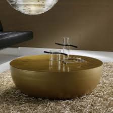 It provides a place to set books, magazines, laptops, a smartphone, and beverages, and is a beautiful way to hide essentials nearby. Gino Carollo Planet Gold Table Gold Coffee Table Golden Coffee Table Gold Table