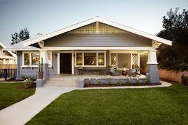 The casual, yet refined craftsman style is found in the stacked front porch, use of natural wood materials, and small details such as an oculus window over the garage. What Is A Bungalow Style Home