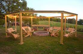 This fire pit is the focal point of any outdoor space. Remodelaholic Tutorial Build An Amazing Diy Pergola And Firepit With Swings Fire Pit Backyard Backyard Hangout Backyard Fire