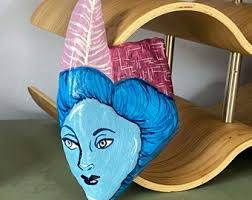 Painted Rock #womanwithhat #paintedrockwoman #featherinherhat #millinerhat  #chapeau #purplechapeau #purplechapeauwithfeather #womanstone