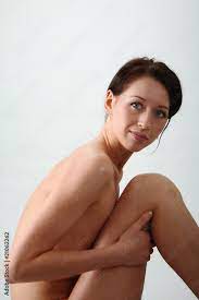 Schöne junge Frau sitzt nackt Stock-Foto | Adobe Stock