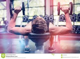 Man Lifting Dumbbell Weights While Lying Down Stock Photo