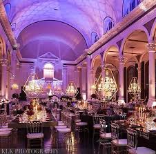 Wedding Reception Chandeliers Table Settings Dim Lighting Purple Lighting High Ceilings Modern Wedding Design Wedding Design Inspiration Purple Lighting
