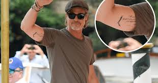 Under his white shirt, we got a peek of a stomach piece as well as a wrist piece with each of his children's initials. Brad Pitt Changes Matching Angelina Jolie Tattoo See The Photos