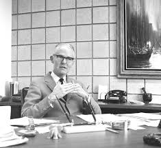 Warren Bostick, Dean of UC Irvine College of Medicine, seated at his desk —  Calisphere