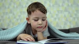 Niño acostado en la cama con un libro. Lectura infantil, Grabaciones de  stock Incluyendo: niño leyendo y niños leyendo