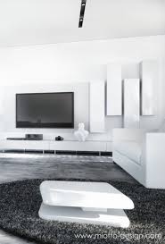 Modern Black And White Living Room With A White Leather Sofa White Coffee Table And White Wall Cabinets A Big Tv In The Middle Of The The Wall Livingroom