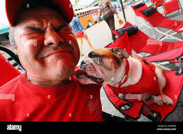 Preston McCallum, of Macon, gets a lick from his Bulldog named Dooley while  tailgating next to EverBank Field