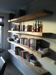 Floating shelves are mounted to the wall with the use of a cleat that the shelf slides over, giving the appearance that the shelf is floating because the support structure isn't visible. Floating Bookshelves Living Room Above Sofa Casas Decoracao Projetos De Casas