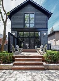 Although the black exterior feels quite masculine and dramatic, the interiors are surprisingly full of soft contrasts, like a turquoise blue laundry room and even a kitchen pantry with bunny knobs! 15 Black House Facades Mysterious Dark But Also Attractive Facade House Modern Farmhouse Exterior Black House Exterior