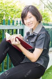 Asian Girl With Short Hair Reading A Book Sitting On A Chair Stock Photo Picture And Royalty Free Image Image 78642815