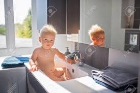 Lay your baby on a flat surface, such as the floor, changing table, counter. Baby Taking Bath In Sink Child Playing With Foam And Soap Bubbles In Sunny Bathroom With