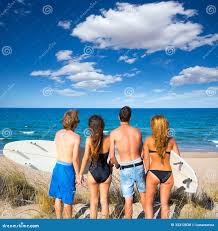 Вид сзади серферов мальчиков и девушек предназначенное для подростков  смотря пляж Стоковое Фото - изображение насчитывающей океан, серфинга:  33312038