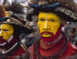 Huli men are easily distinguished by their dazzling ocher painted faces and  cassowary quills, placed through the nasal septa. Their enormous wigs,  adorned with Bird of Paradise feathers, are made from the