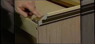 Hold two short 1x4s flat against ceiling, overlapping at cabinet corner. How To Install Crown Molding On Your Cabinets Construction Repair Wonderhowto